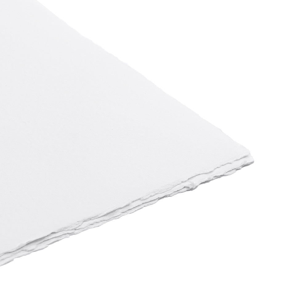 Eine Nahaufnahme der Ecke eines weißen Blattes handgeschöpftes Papier mit einem rauen, unregelmäßigen Rand – perfekt für die Gestaltung exquisiter Hochzeitseinladungskarten.