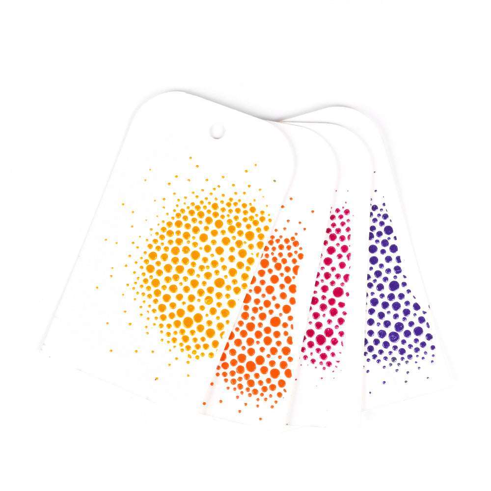 Vier weiße Anhänger mit farbenfrohen Punktmustern in Gelb, Orange, Rosa und Lila - erstellt mit The Crafters Workshop Stencil Butter - sind auf einem weißen Hintergrund aufgefächert.