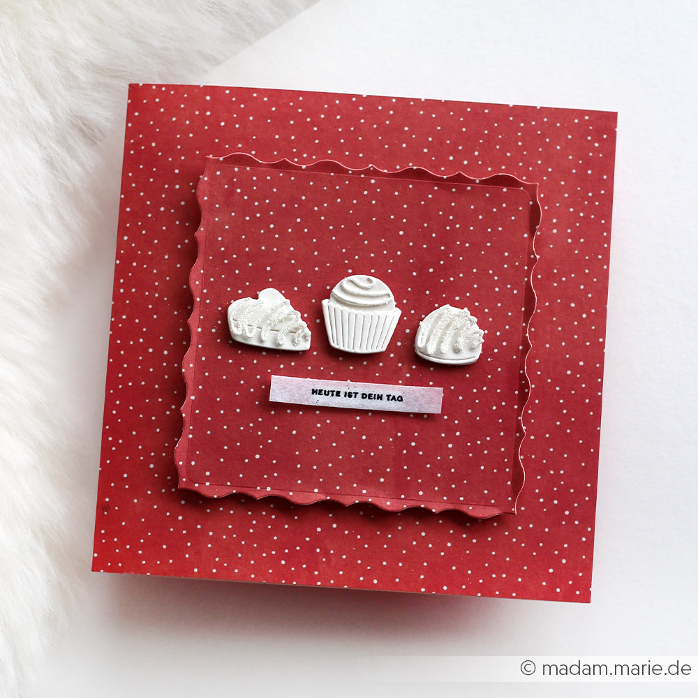 Rote Polka-Dot-Karte von Alexandra Renke mit drei weißen Cupcake-Motiven und der deutschen Botschaft "Heute ist dein Tag". Ideal für Ihre Sammlung oder als Teil eines Kreativpakets!.