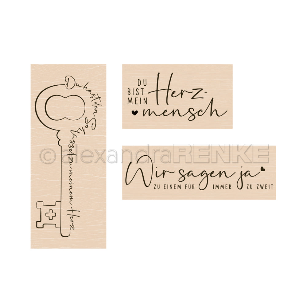 Drei Alexandra Renke Holzstempel mit deutschen Liebessprüchen und einer Schlüsselkontur, perfekt für die Kreativität, sind auf einem weißen Hintergrund angeordnet.