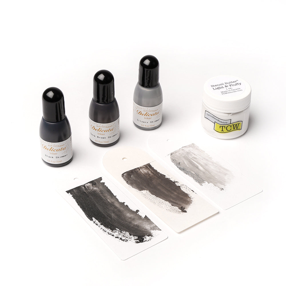 Vier Flaschen mit schwarzer und grauer Tinte von alexandrarenke, ein weißes Glas Texturpaste und drei bemalte Musterkarten für kreative Papierarbeiten auf weißem Hintergrund.