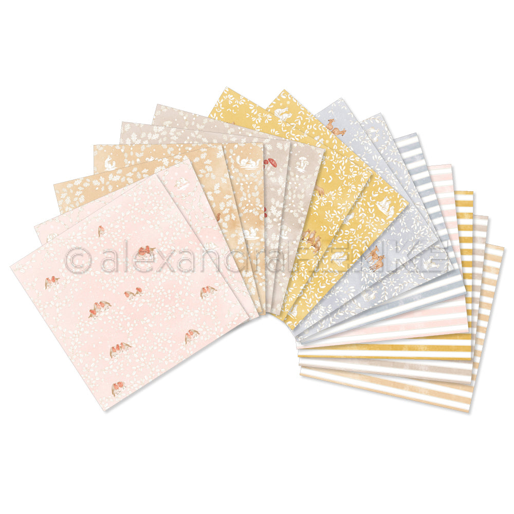 Eine fächerförmige Ausstellung verschiedener Scrapbook-Papierbündel mit Blumen-, Wald- und Streifenmotiven, die die Kreativität anregen.
