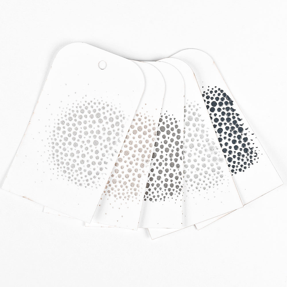 Fünf weiße Karten mit gepunkteten Kreismustern in verschiedenen Farbtönen, die mit Mixed-Media-Techniken von The Crafters Workshop hergestellt wurden, sind auf einem weißen Hintergrund aufgefächert.