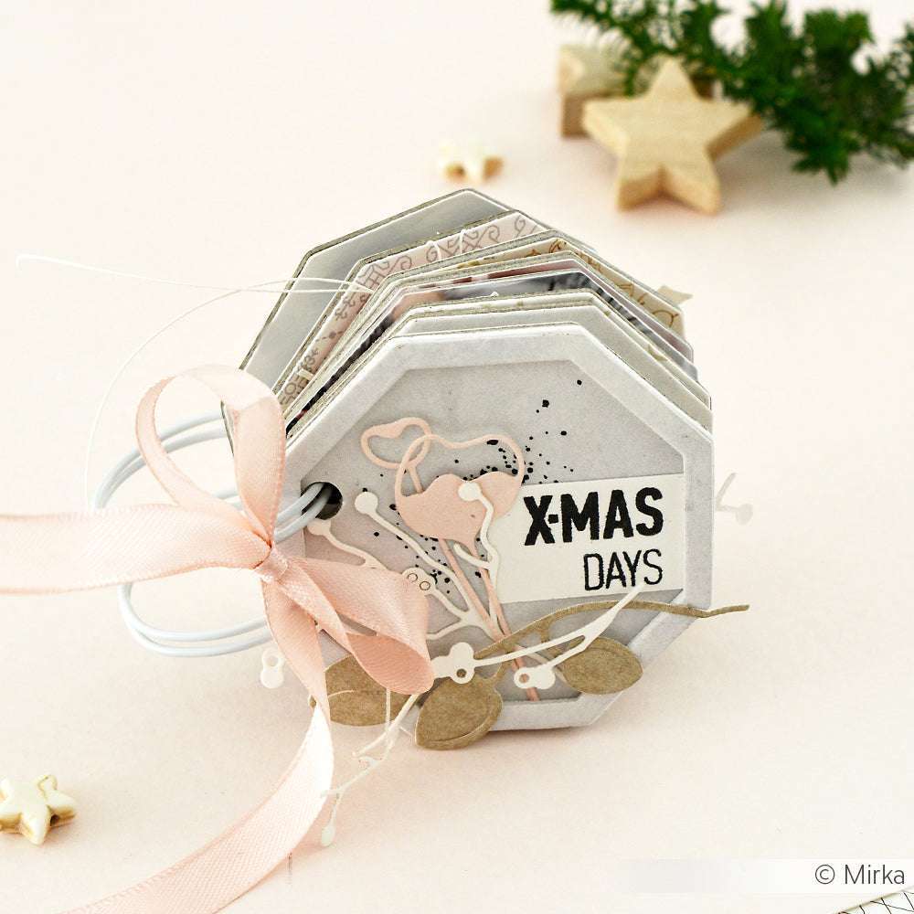 Sechseckiges, handgefertigtes Büchlein mit XMAS DAYS auf dem Umschlag, rosafarbenem Band, festlichem Dekor und aufwändigen Details, die mit Deep Edge Stanzen von Alexandra Renke hergestellt wurden.
