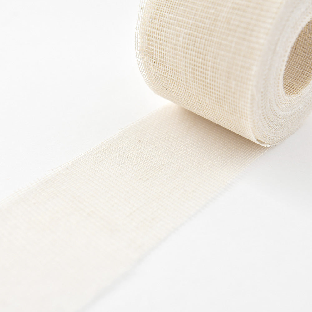 Eine Rolle ☆ weißes Netzgewebe Gazeband wird auf einer weißen Fläche abgerollt.