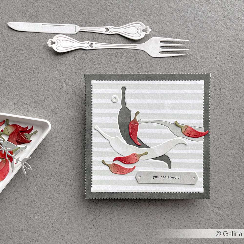 Eine handgefertigte Karte von Alexandra Renke zeigt rote und weiße Chilischoten aus Motivstanze Chilis und den Text "Du bist etwas Besonderes" auf einem gestreiften Hintergrund.