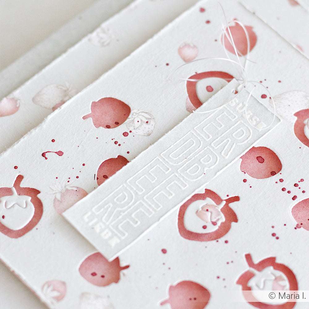 Weiße Karte mit rosafarbenem Erdbeermuster, erstellt mit dem Alexandra Renke Erdbeertraum Photopolymer Stempel und einem weiß geprägten Anhänger "Sweet Life", befestigt mit weißem Garn.