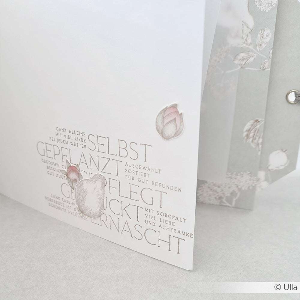 Eine Nahaufnahme einer Karte mit deutschen Worten, floralen Illustrationen und sanften Pastellfarben auf hellem Hintergrund, hergestellt mit dem Clear Stamp Set "Aus meinem Garten" von Alexandra Renke.