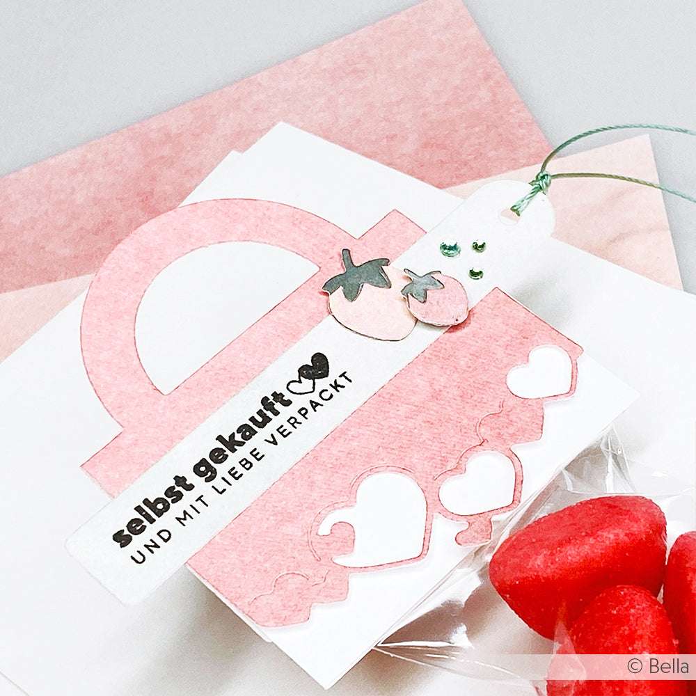 Ein rosafarbener Papiertütenanhänger mit Herzen, deutschem Text, Erdbeeren und Blättern. Entworfen mit dem Clear Stamp Set von Alexandra Renke für scharfe Details.
