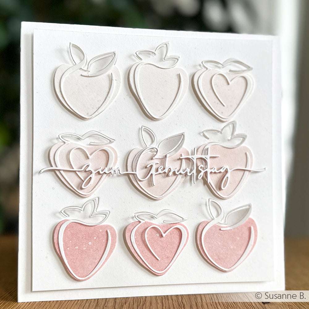 Eine quadratische Karte von Alexandra Renke mit neun rosafarbenen und weißen Erdbeerausschnitten, die mit Motivstanze oder Stanzsystemen hergestellt wurden, und elegantem kursivem Text in der Mitte.