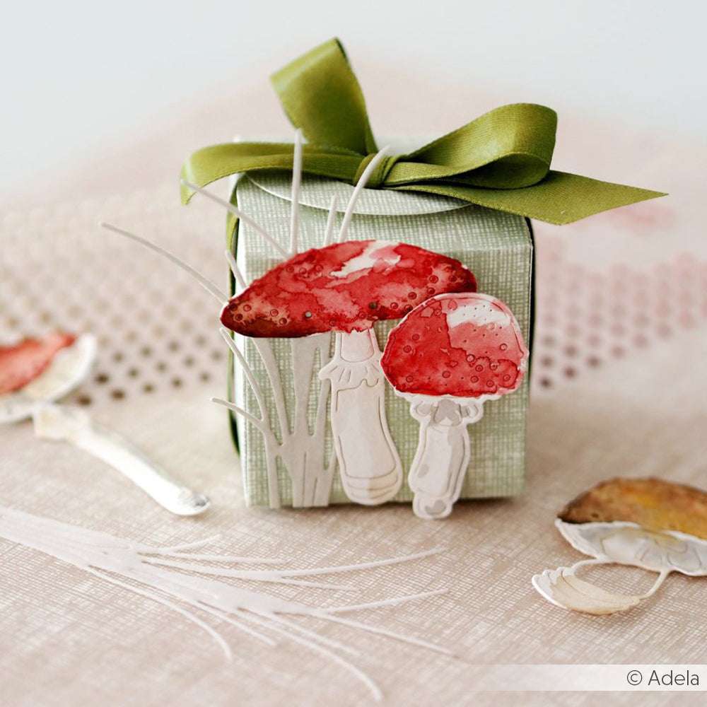 Kleine grüne Geschenkbox mit grünem Band, dekoriert mit Alexandra Renke Designpapieren, roten Pilzausschnitten aus der Alexandra Renke Motivstanze Schnittlauch und Papiergras.