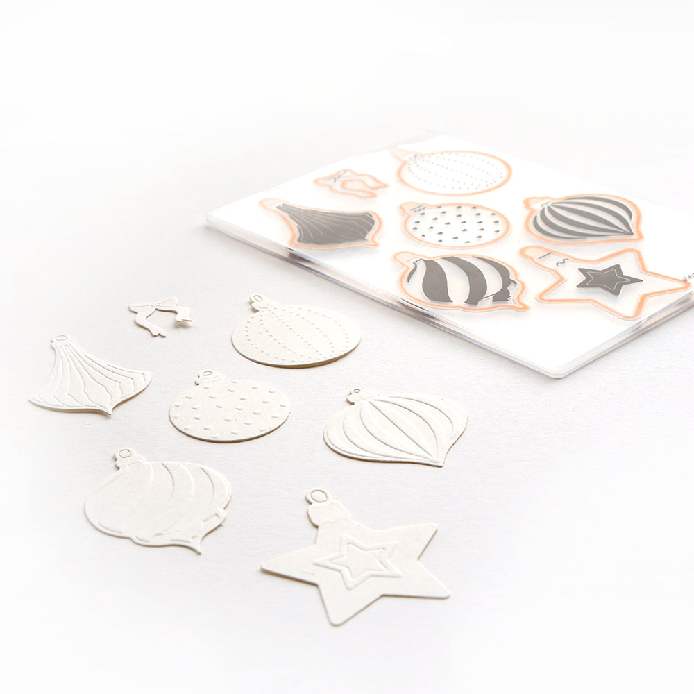 Alexandra Renke Festtagskugeln ornamentale Stanzteile und passende Konturenschablonen sind auf einer weißen Fläche angeordnet.