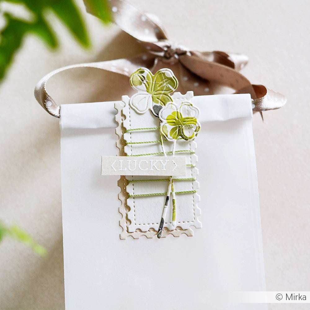 Weiße Geschenktüte von Alexandra Renke mit Schleife, grünem Klee-Dekor, Nähten und einem LUCKY-Etikett - perfekt, um sie mit Ihrem Lieblings-Photopolymer- oder Klarsicht-Stempelset zu kombinieren und ihr eine persönliche Note zu verleihen.