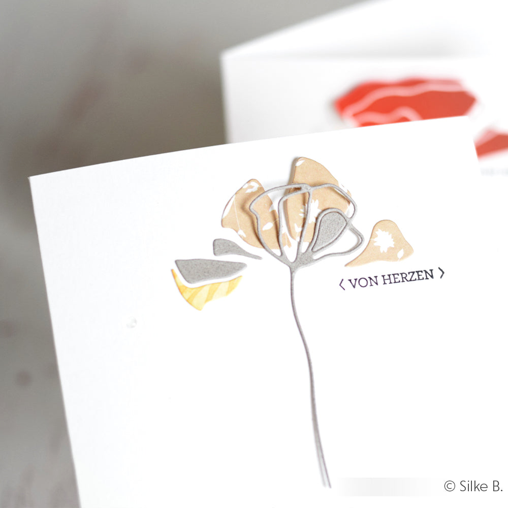 Eine Nahaufnahme einer Karte mit zarten Motiven, die mit Alexandra Renke Photopolymer Stempel erstellt wurden, perfekt für einzigartige Papierprojekte.