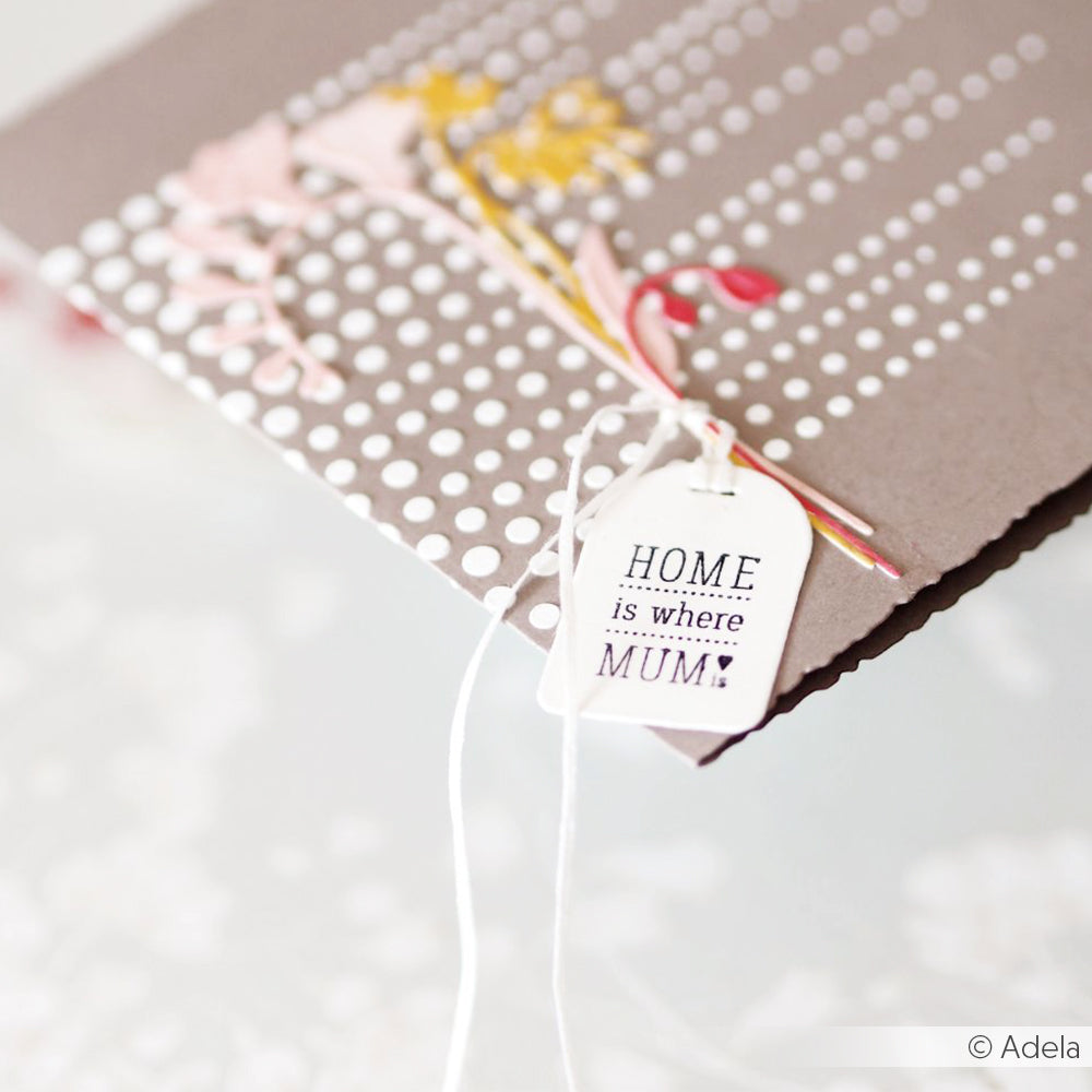 Eine Karte von Alexandra Renke mit weißen Punkten, einem Anhänger "HOME is where MUM is", kleinen Blumen und dem deutlich gestempelten Satz "Für Mama".