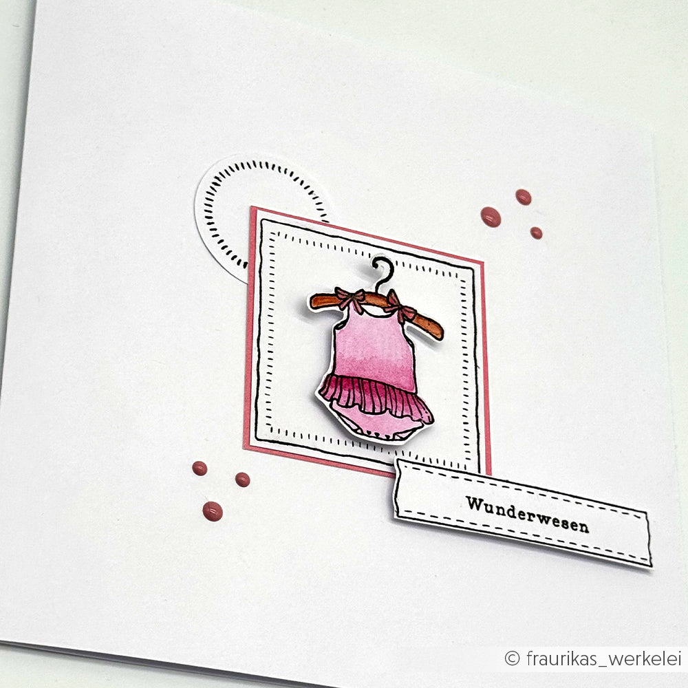 Die handgefertigte Karte von Alexandra Renke zeigt ein rosa Kleid auf einem Bügel, geometrische Akzente und das Etikett "Wunderwesen" mit Clear Stamp Photopolymer Stempel - ideal für besondere Momente wie "It's a girl!.
