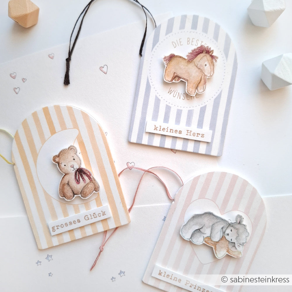 Drei pastellfarbene Geschenkanhänger von Alexandra Renke mit niedlichen Tieren, deutschen Sprüchen und "It's a girl"-Akzenten - perfekt für die Kombination mit Ihren Lieblingsmotiven von Photopolymer Stempel oder Clear Stamp. Ausgestellt auf weißem Hintergrund.