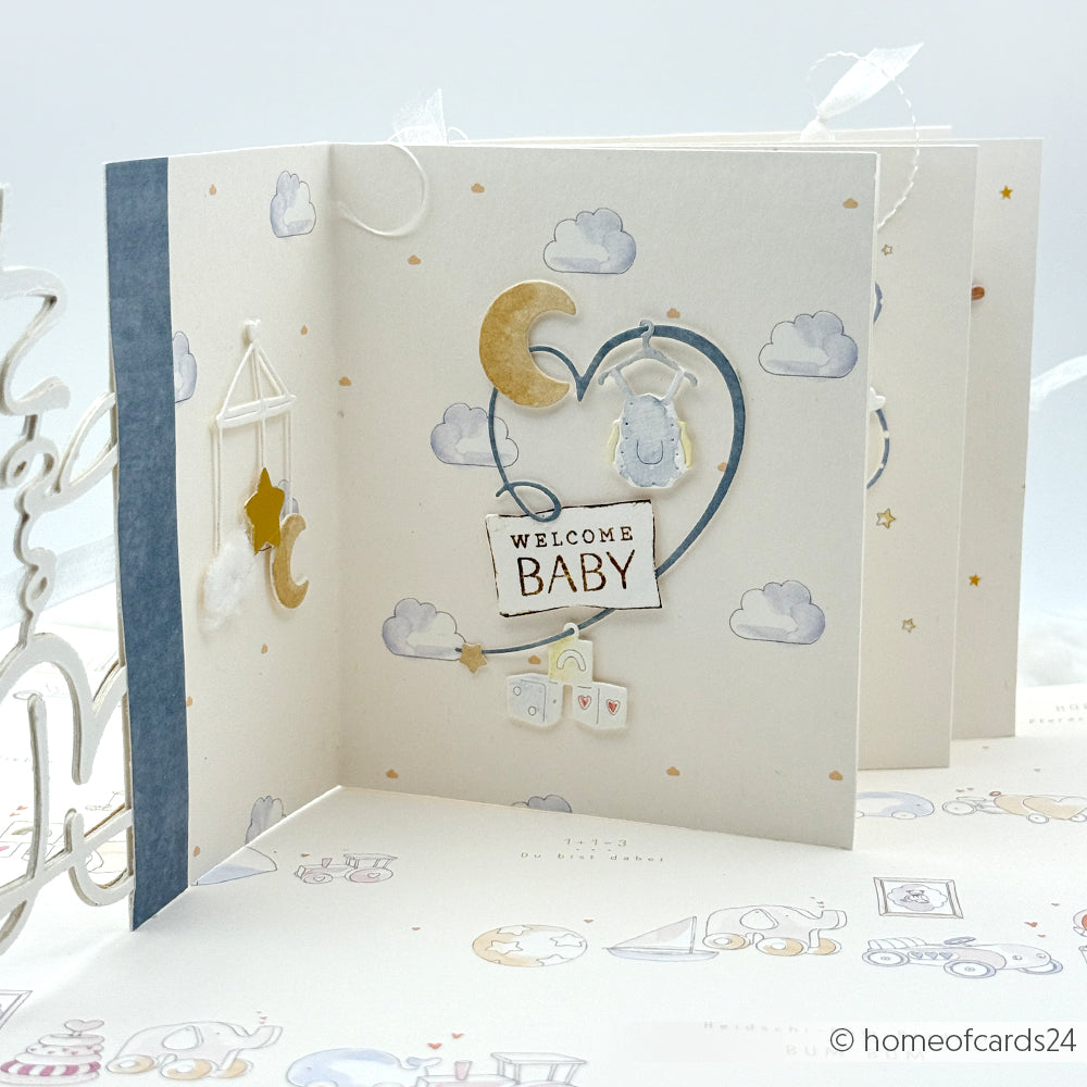 Handgemachte Welcome Baby-Karte von Alexandra Renke mit Wolken, Sternen, einer Mondsichel und pastellfarbenen Dekorationen zum Thema Baby mit Clear Stamp-Details für einen charmanten Touch.