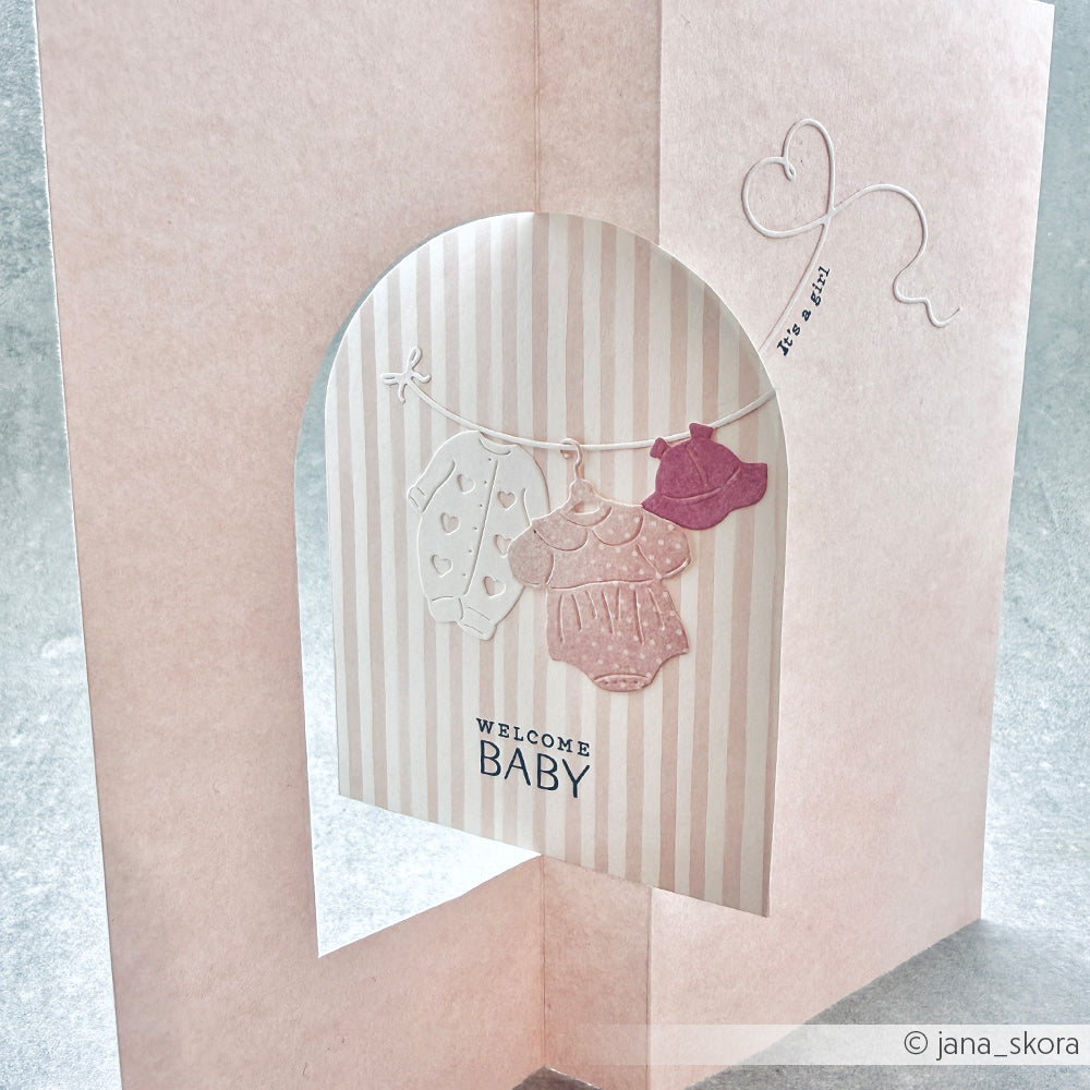 Die rosa Babymädchenkarte mit 3D-Ausschnitt von Alexandra Renke zeigt Onesies auf einer Linie und den Text "WELCOME BABY" - ideal für die Kombination mit Ihren Lieblingsmotiven aus Photopolymer-Stempeln oder Klarsichtstempeln.