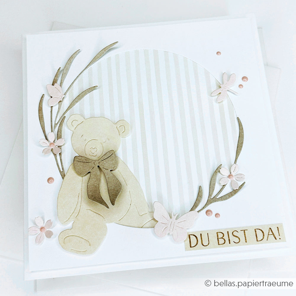 Handgemachte Karte von Alexandra Renke mit einem Papierteddy, Blumen und "DU BIST DA!" auf einem gestreiften, kreisförmigen Hintergrund - perfekt für Ihre nächsten Papierprojekte oder zur Kombination mit Clear Stamp Designs.