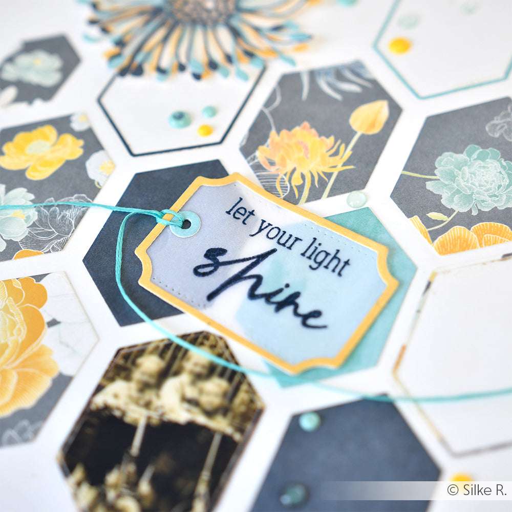 Sechseckige Karte mit gelben Blumen und einem Anhänger, hergestellt mit dem Alexandra Renke Ticket-Tags DieCut System, mit dem Schriftzug "Let your light shine" in Schreibschrift.