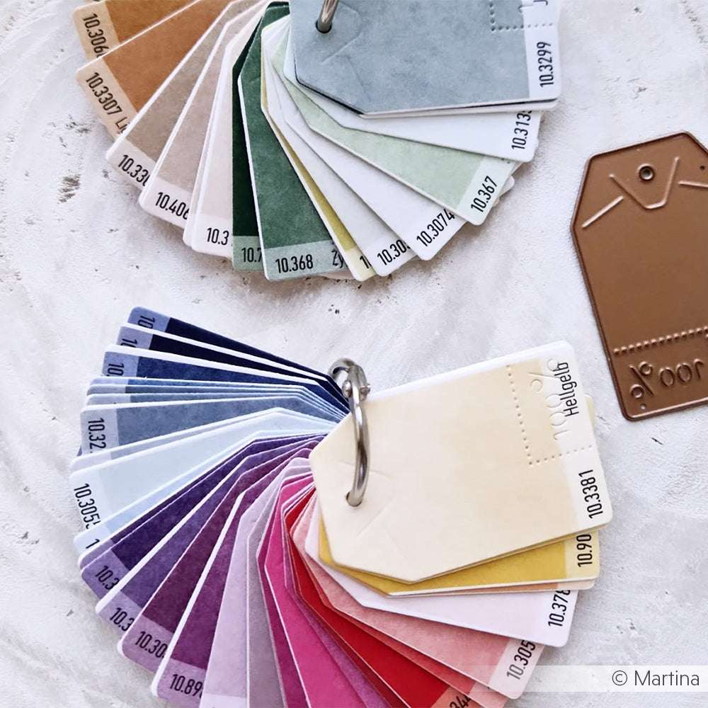 Zwei Schlüsselanhänger zeigen bunte Farbmusteranhänger aus leuchtenden Alexandra Renke Designpapieren, fächerförmig angeordnet auf hellem Hintergrund.