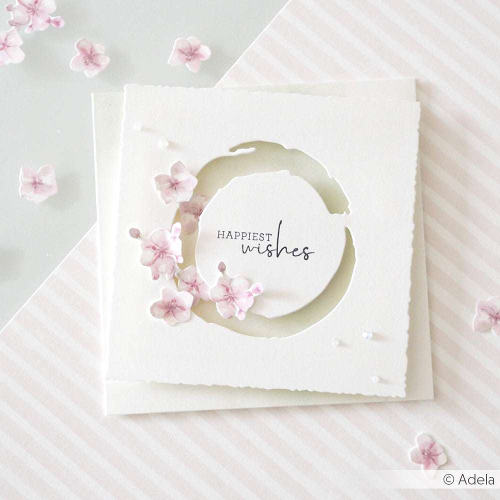 Weiße Grußkarte von Alexandra Renke mit dem Text "Happiest wishes" und hellrosa Blumen auf pastellfarbenem, gestreiftem Hintergrund - ideal, um sie mit Ihren Lieblingsdesignpapieren zu kombinieren oder mit DieCut Systemen einzigartige Akzente zu setzen.