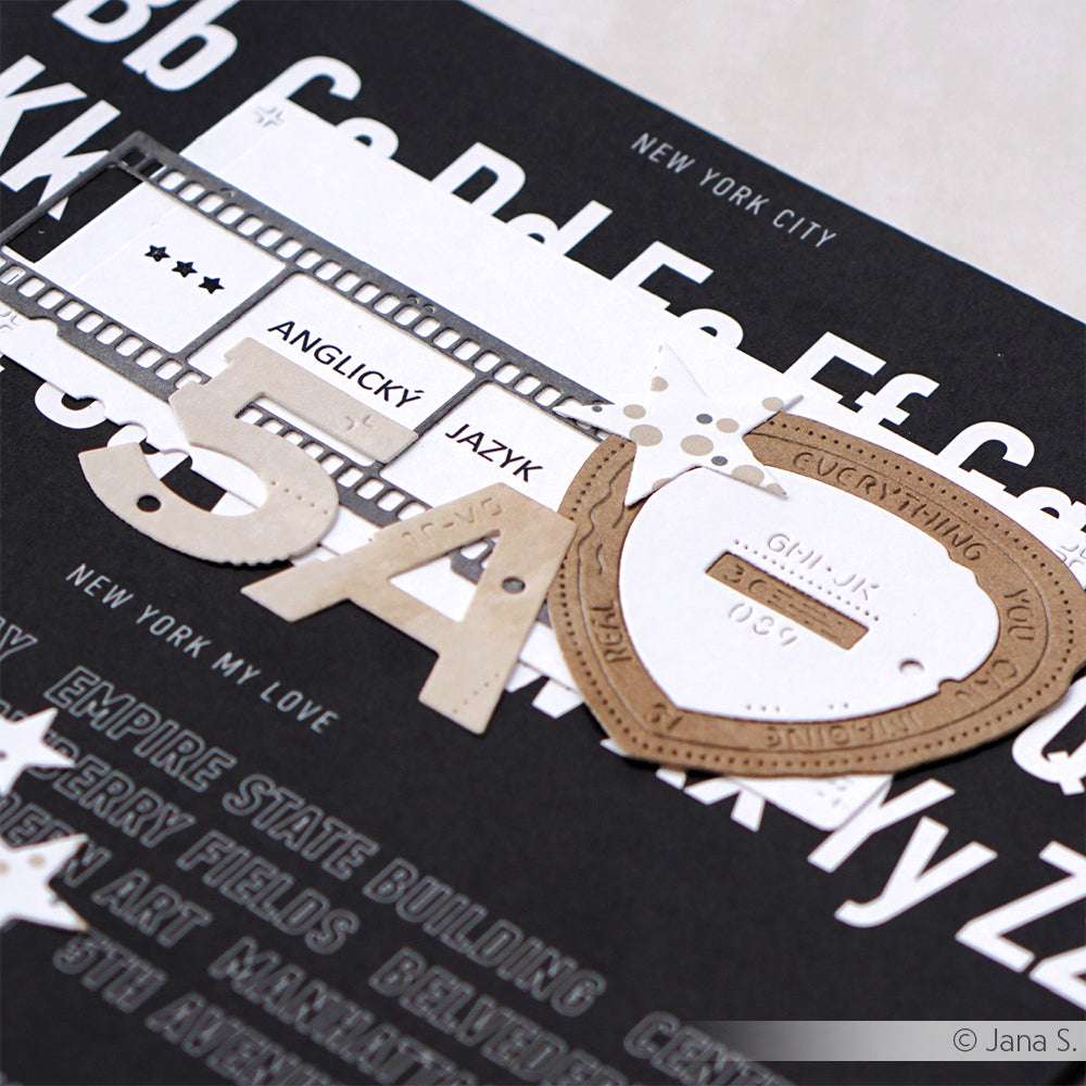 Nahaufnahme einer Scrapbook-Seite mit Buchstaben, Filmstreifen und ANGLICKÝ JAZYK auf einem schwarzen NYC-Hintergrund, erstellt mit Alexandra Renke Motivstanze DieCut Systeme und kreativen Designpapieren.