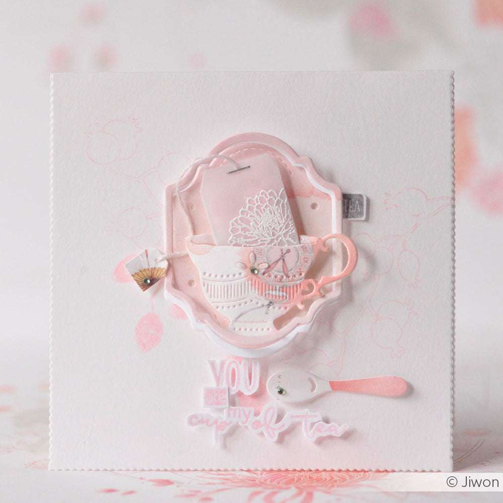 Handgefertigte Karte von Alexandra Renke mit einer Teetasse, einem Teebeutel, einem Löffel und "You are my cup of tea" in zartem Rosa und Weiß. Gefertigt mit Stanzsystemen für detailliertes Design und hochwertigen Designpapieren für ein elegantes Finish.