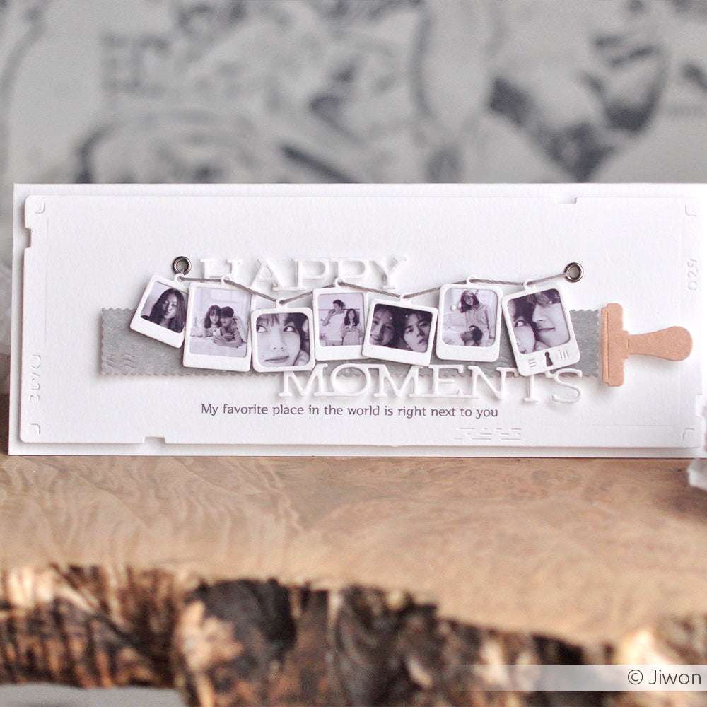 Eine handgefertigte Karte mit Mini-Fotodrucken, die mit der Alexandra Renke Polaroidrahmen-Stanze ausgestanzt und mit dem Text "HAPPY MOMENTS" und "My favorite place in the world is right next to you" verziert wurden.