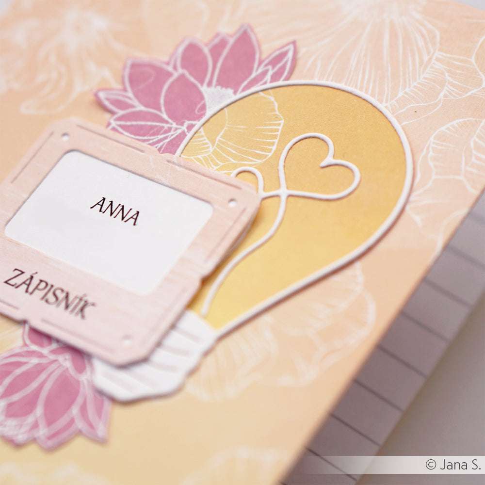 Ein Notizbuchumschlag von Alexandra Renke mit Blumen, einer Glühbirne in Herzform und einem "Anna Zápisník"-Etikett - ideal für Fans des Diarahmen-Sets oder für alle, die gerne Motivstanze-Stanzen für kreative Projekte verwenden.