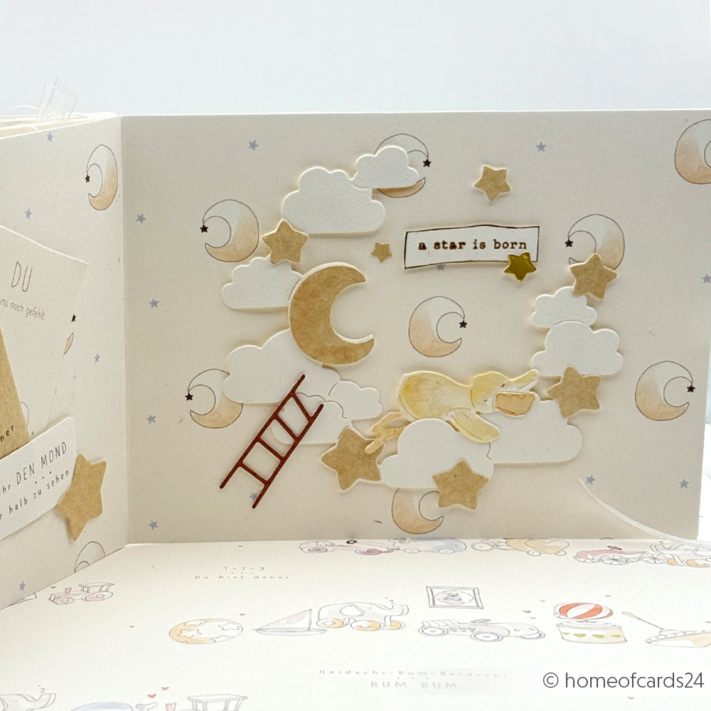 Handgemachte Karte mit Wolken, Sternen, Mond und Leiter, hergestellt mit Alexandra Renke Designpapieren und Motivstanze Nachthimmelkranz, plus Text "a star is born" auf pastellfarbenem Hintergrund.