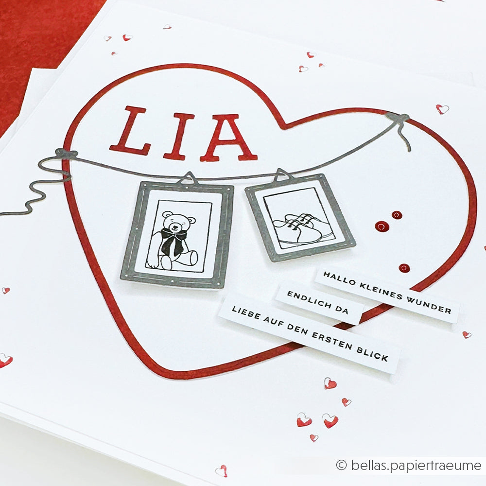 Handgefertigte Karte von Alexandra Renke mit einem roten Herz von Motivstanze Herz, "LIA", Bärenskizze, Bilderrahmen, deutschem Text und weißem Designpapiere-Hintergrund.