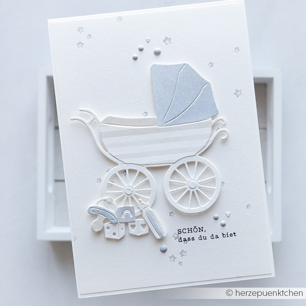 Weiße Karte von Alexandra Renke mit einem Kinderwagen aus Motivstanze Kinderwagen, kleinen Geschenkboxen und dem Text "SCHÖN, dass du da bist" - ideal zum Personalisieren mit Ihren Lieblingsdesignpapieren oder Stanzsystemen.