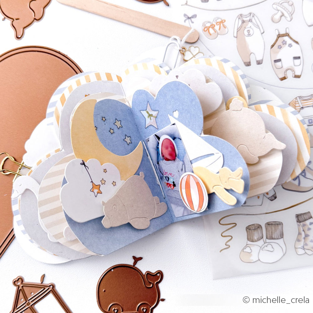 Das wolkenförmige Scrapbook von Alexandra Renke mit Aufklebern zum Thema Baby - Sterne, Mond, Segelboot und Pastellfarben - eignet sich perfekt, um Projekte mit Stanzen für Designpapier oder einem beliebigen DieCut System aufzuwerten.
