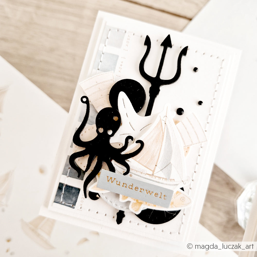 Handgefertigte Karte mit Ausschnitten eines schwarzen Oktopus, eines Dreizacks und eines Segelboots, die mit Stanzformen von Alexandra Renke und der Motivstanze „Meeresspaß“ von Stanzsysteme gefertigt wurden; mit der Aufschrift „Wunderwelt“ auf strahlend weißem Hintergrund.