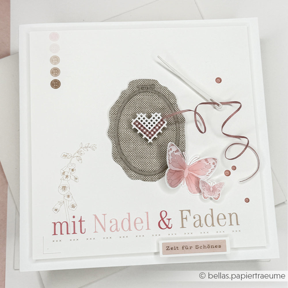 Quadratische, handgefertigte Karte von Alexandra Renke, gestaltet mit Designpapieren. Mit Stickrahmen, Nadel, rosa Herz, Schmetterling und dem Schriftzug „mit Nadel & Faden“. Verziert mit der Motivstanze „Stickrahmen Oval“ für einen bezaubernden Abschluss.