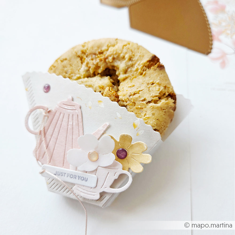 Ein Plätzchen in einem dekorativen Papierhalter von Alexandra Renke, gestaltet mit der Motivstanze „Blumiges Teeset“ mit Teekanne, Tassen, Blumen und dem Schriftzug „Just For You“ auf der Vorderseite.