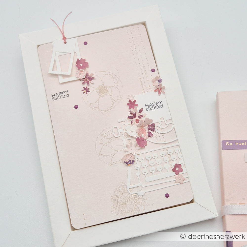 Handgefertigte, zartrosa Geburtstagskarte von Alexandra Renke mit Schreibmaschinen- und Blumenmotiven, gestaltet mit der Motivstanze „Schreibmaschine“, zarten Designpapieren und kleinen rosa und lila Blumenakzenten.