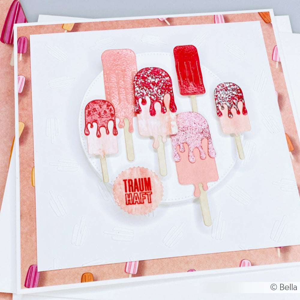 Handgefertigte Karte mit fünf rosafarbenen und roten Eis am Stiel, hergestellt mit der Motivstanze Eis am Stiel von Alexandra Renke und dem Schriftzug TRAUMHAFT" auf einem runden Etikett in der Mitte.