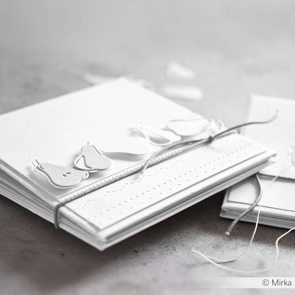 Ein Stapel weißer Alexandra Renke-Karten mit birnenförmigen Ausschnitten aus einer Motivstanze Birnenreihe ist mit einer silbernen Schnur umwickelt.