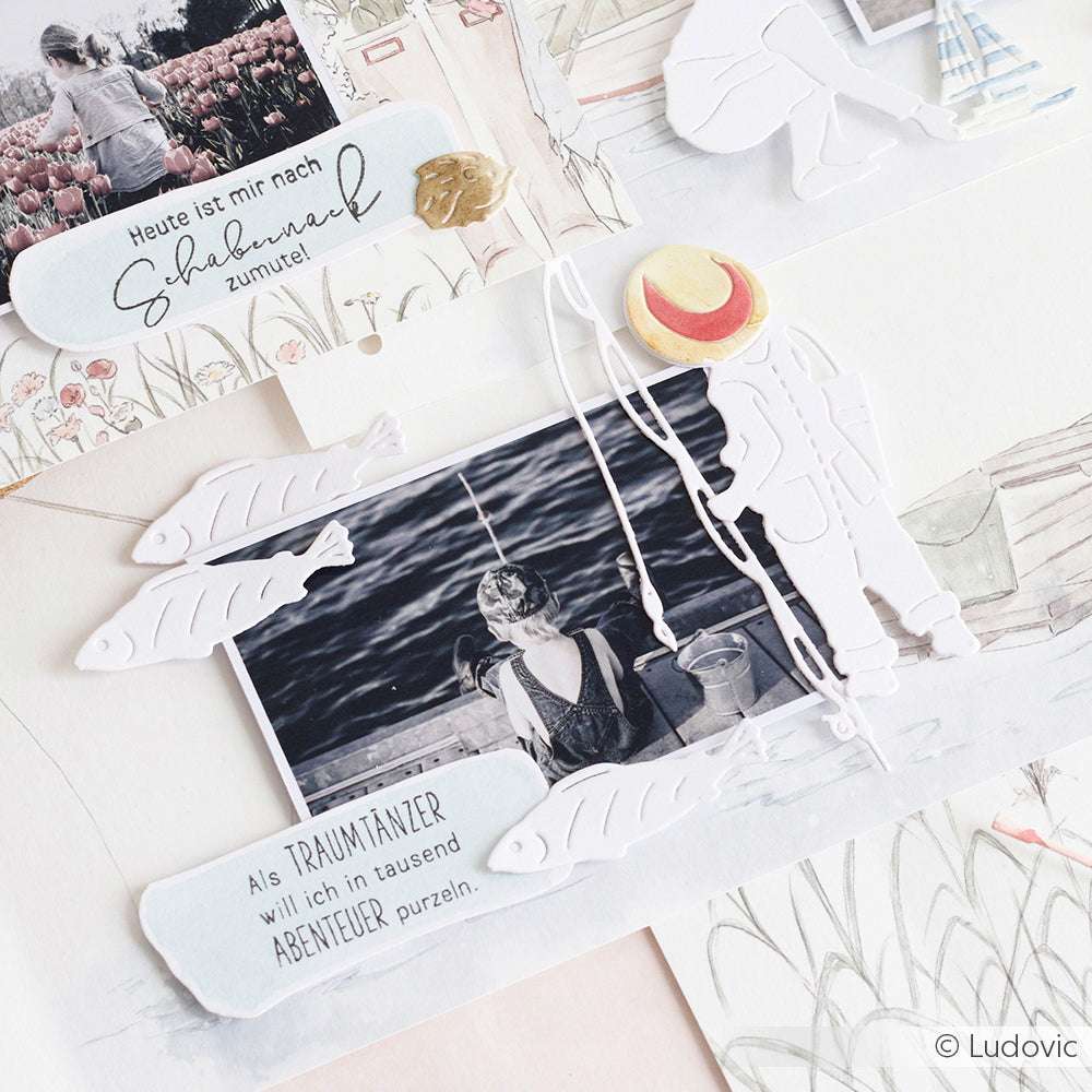 Ein Schwarz-Weiß-Foto einer Frau beim Angeln ist umgeben von Papierfischen, die mit Alexandra Renke Stanzen und deutschem Text auf einer Scrapbook-Seite hergestellt wurden.