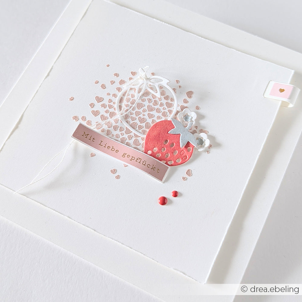 Handgemachte Karte von Alexandra Renke mit einer roten Erdbeere, Herzen und dem Text "Mit Liebe gepflückt" auf weißem Hintergrund. Hergestellt mit Motivstanze Mini Erdbeeren und hochwertigen Designpapieren für eine einzigartige Note.