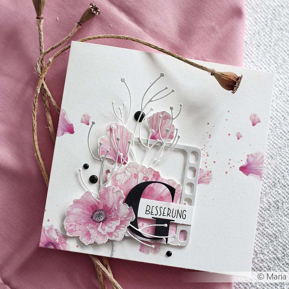 Grußkarte mit rosafarbenen Blumen, dem Text "G Besserung" und dekorativen Elementen auf einem rosafarbenen Stoffhintergrund, gestaltet mit dem Artistbäume Set und der Motivstanze von Alexandra Renke für einzigartige Designs.