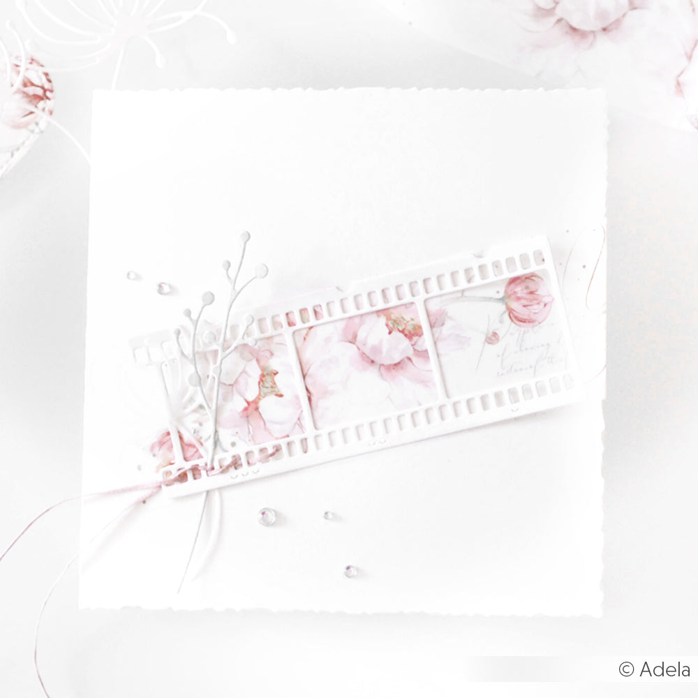 Eine zarte, pastellfarbene Blumenkarte von Alexandra Renke mit einem Filmstreifenmuster, rosa Knospen-Set-Blumen, Perlen und weißen Akzenten - ideal, um die Präzision der Motivstanze Stanzsysteme zu unterstreichen.