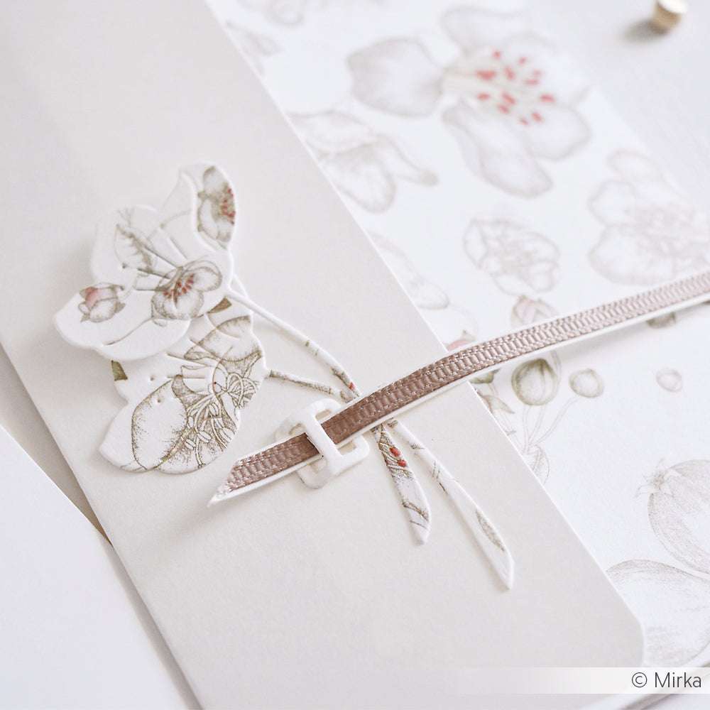 Nahaufnahme einer Karte mit Blumenmuster aus Alexandra Renke-Papier, verziert mit einem rosa Band und einem zarten Quittenblüten-Ausschnitt.