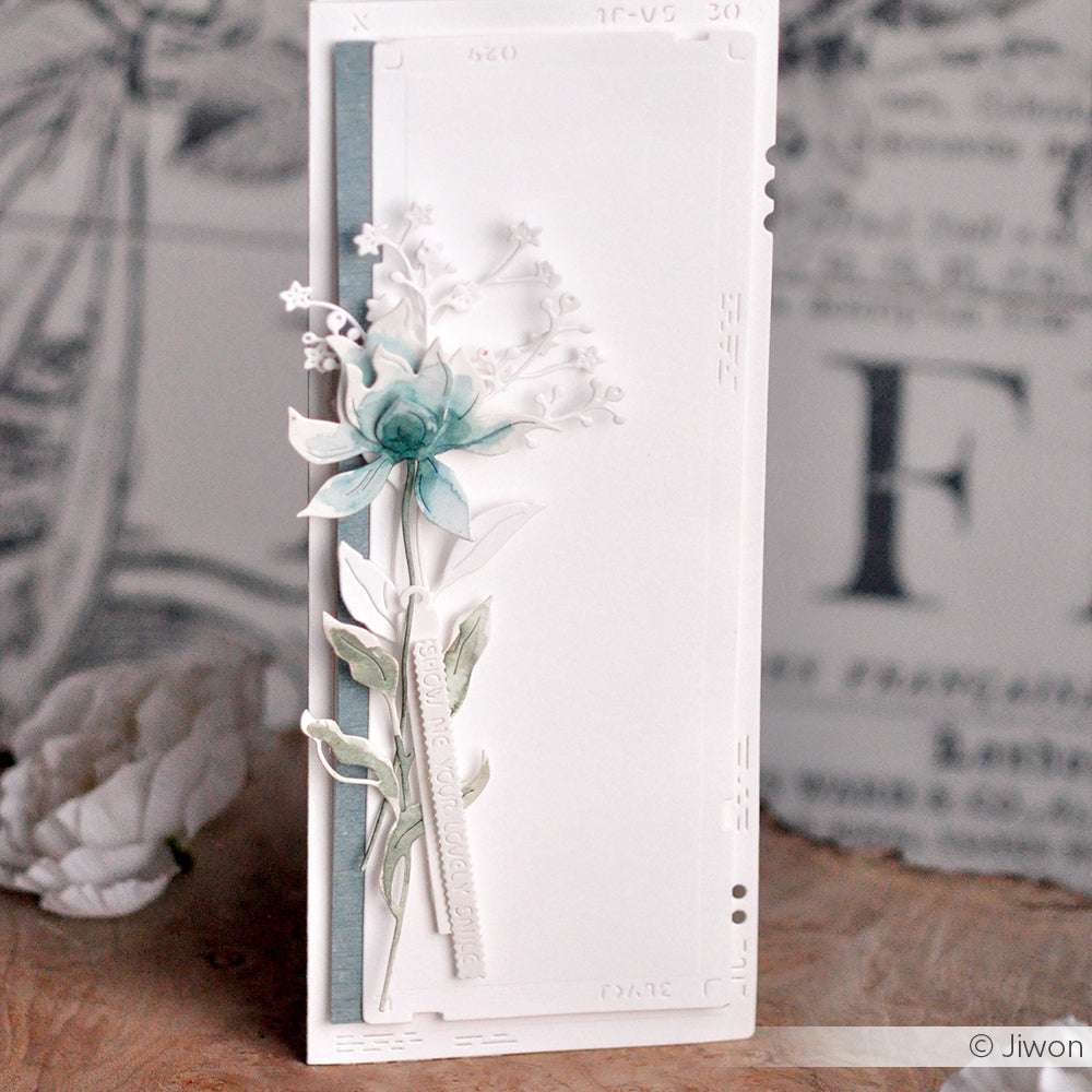 Handgefertigte Karte von Alexandra Renke mit einer zarten blau-grünen Schichtblume 4 und Blättern auf weißem, geprägtem Hintergrund, vertikal gestylt und mit Stanzen für detaillierte Akzente versehen.