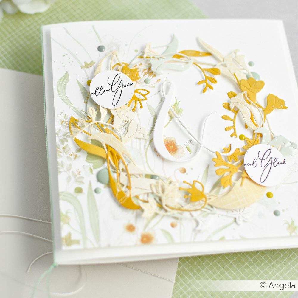 Handgefertigte Grußkarte von Alexandra Renke mit einem gelben und grünen Blumenkranz, hergestellt mit der Blätter Trio Stanze, und eleganter Kalligrafie auf weißem Hintergrund.