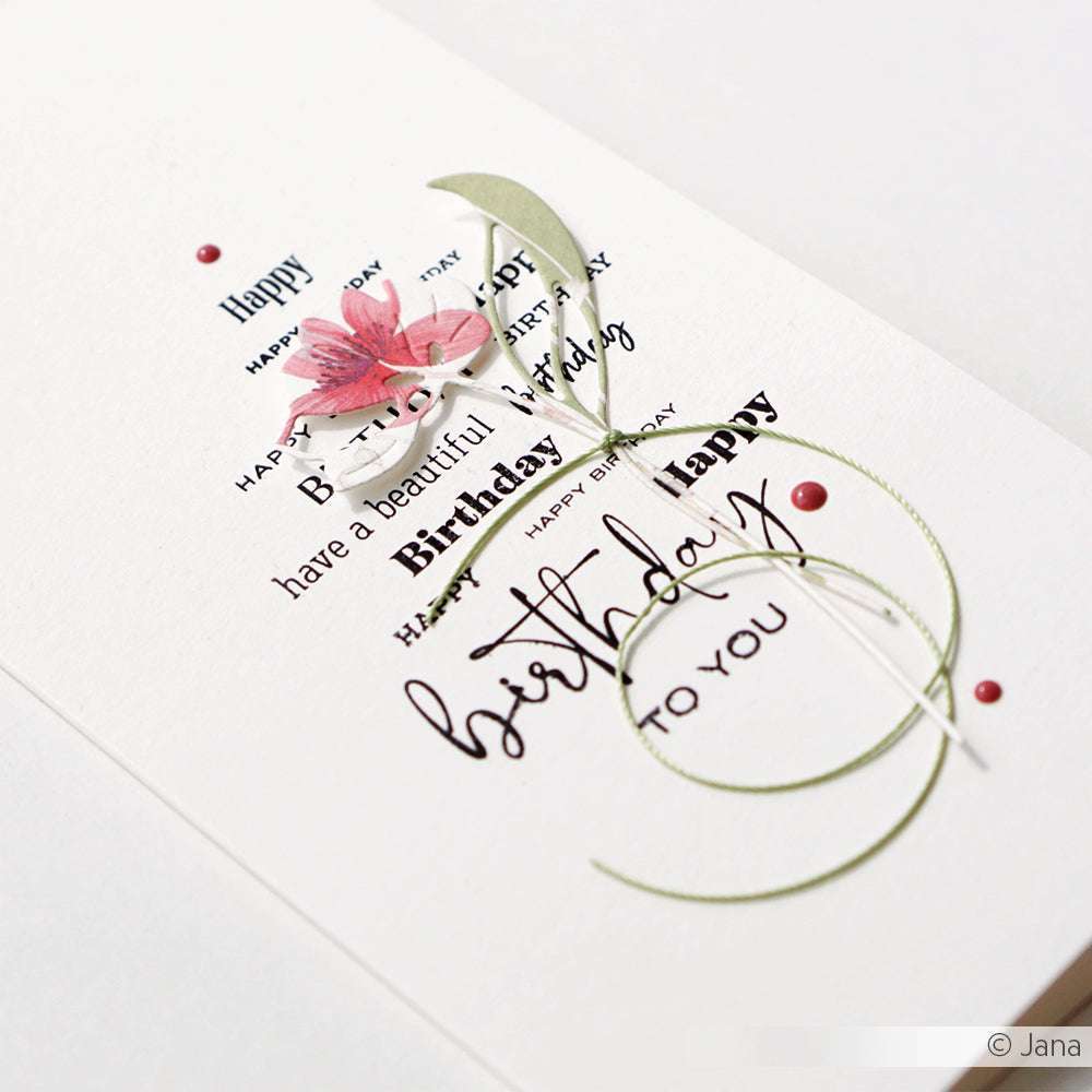 Elegante Geburtstagskarte von Alexandra Renke, gestaltet mit Designpapieren, mit geschichtetem Text, einer rosa Blume, die mit der Motivstanze Wunderlotus DieCut Systeme geschnitten wurde, und grünen Zierlinien auf weißem Hintergrund.