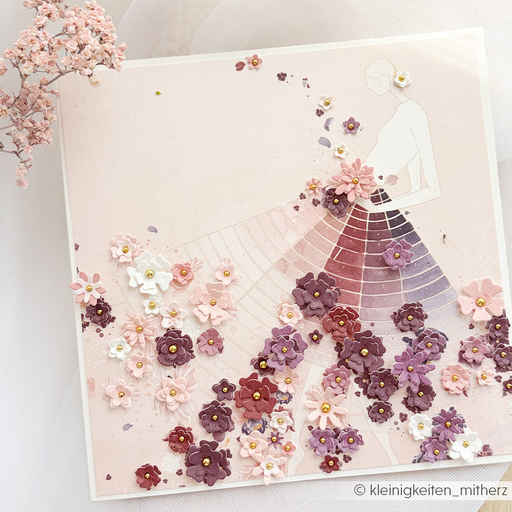 Handgefertigte Blumenkarte von Alexandra Renke mit der Skizze einer Frau in einem 3D-Kleid aus rosa und lila Blumen, gestaltet mit der Motivstanze „Streublümchen“ und hochwertigen Designpapieren für einen eleganten, strukturierten Look.